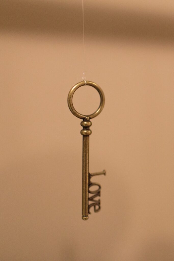 a golden key hanging from a hook on a wall